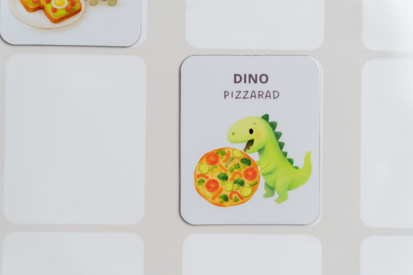 Mealomat Dino-Rezeptmagnet Pizza am Wochenplaner – für selbstständige Essensplanung von Kindern.